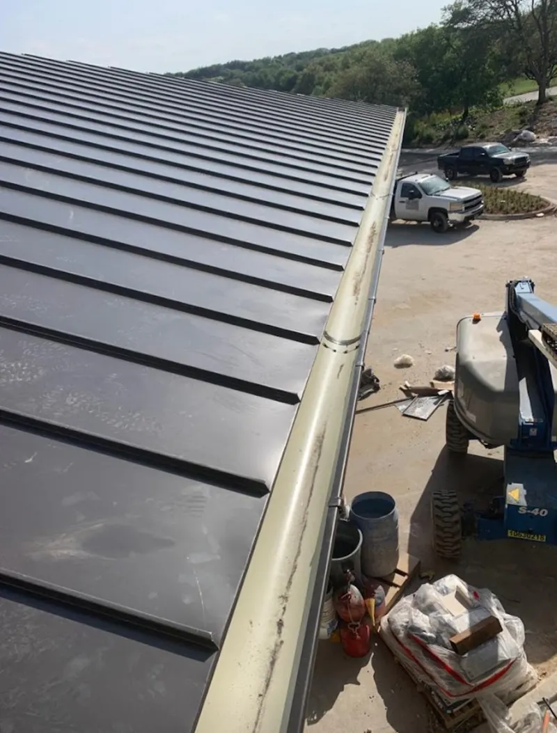 Standing seam panel and gutter detail on a metal roofing jobsite in Heath
